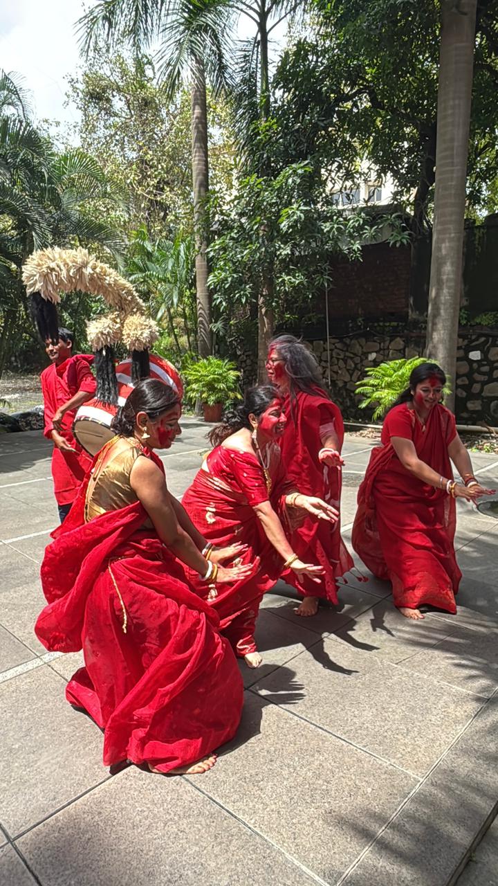 Women celebrating together outdoors in red and white sarees