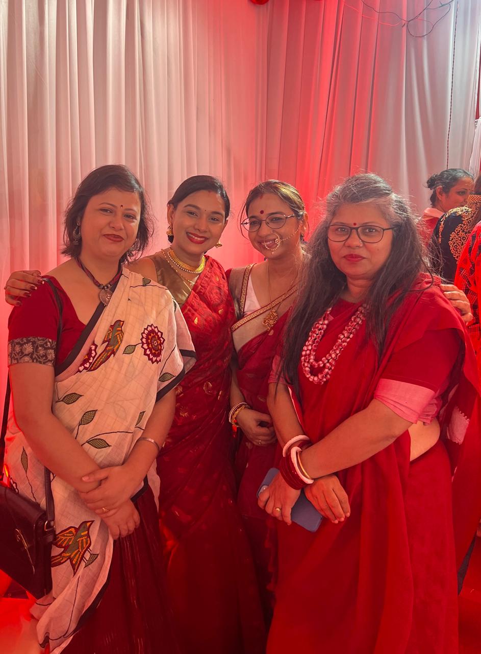 Four community members smiling together at Pujo 2025